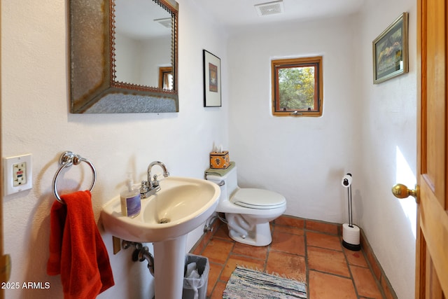 bathroom featuring baseboards, visible vents, toilet, and a sink