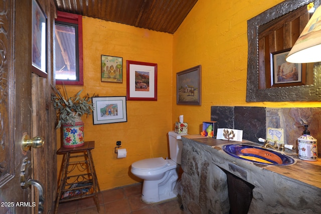 bathroom with vaulted ceiling, toilet, wood ceiling, vanity, and tile patterned flooring