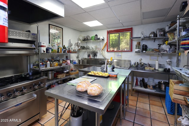 kitchen featuring stainless steel countertops, high end stainless steel range, open shelves, and a paneled ceiling