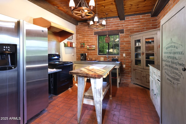 kitchen with wooden ceiling, a sink, black range with electric cooktop, brick floor, and stainless steel refrigerator with ice dispenser