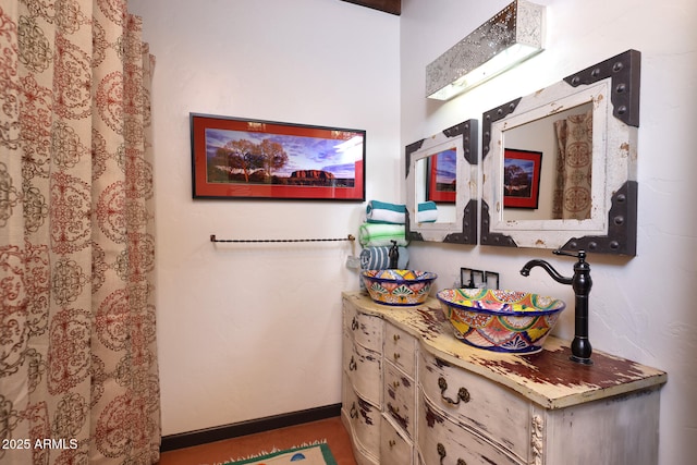 bathroom featuring baseboards and a sink