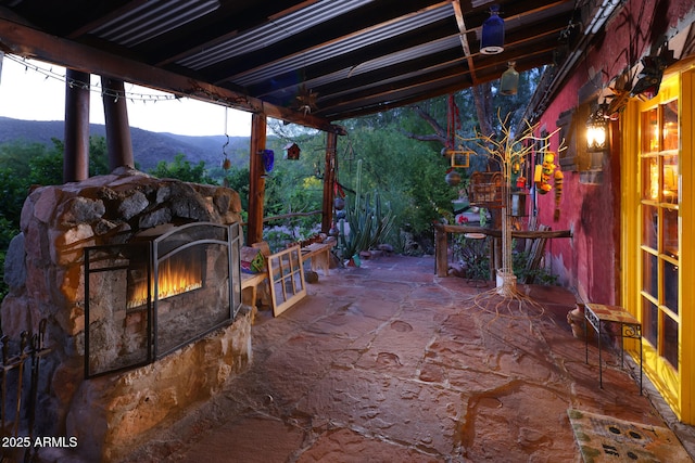view of patio / terrace with an outdoor stone fireplace and a mountain view
