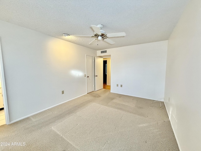 empty room featuring carpet flooring, ceiling fan, and a textured ceiling