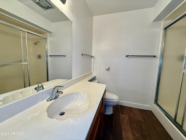 bathroom with vanity, hardwood / wood-style flooring, toilet, and walk in shower