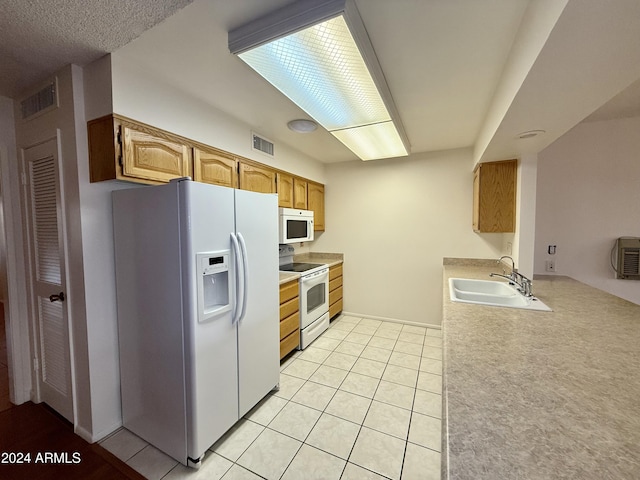 kitchen featuring light tile patterned flooring, white appliances, and sink