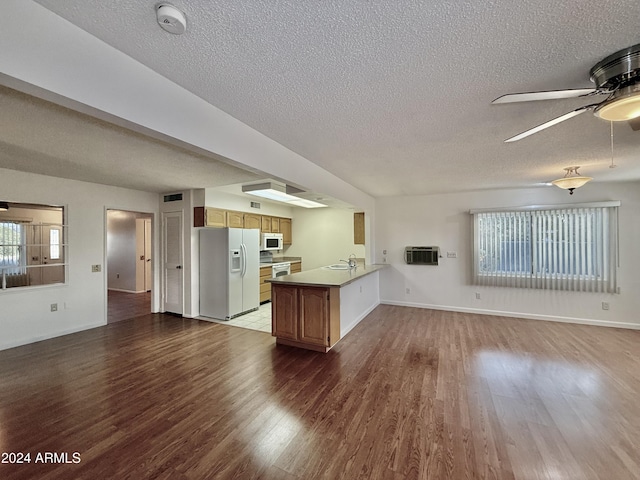 kitchen featuring kitchen peninsula, dark hardwood / wood-style flooring, white appliances, ceiling fan, and sink