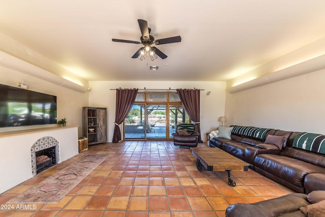 tiled living room with ceiling fan and a tiled fireplace