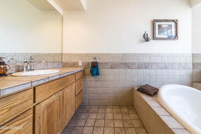 bathroom featuring a bathing tub, tile patterned flooring, vanity, and tile walls