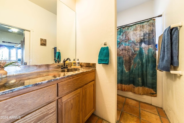 bathroom featuring tile patterned flooring, vanity, and walk in shower