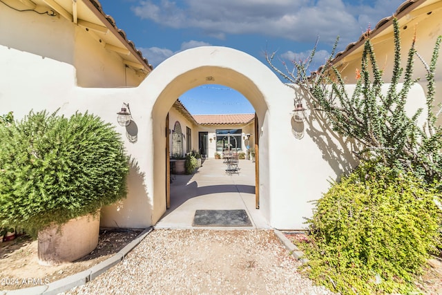 view of exterior entry with a patio area