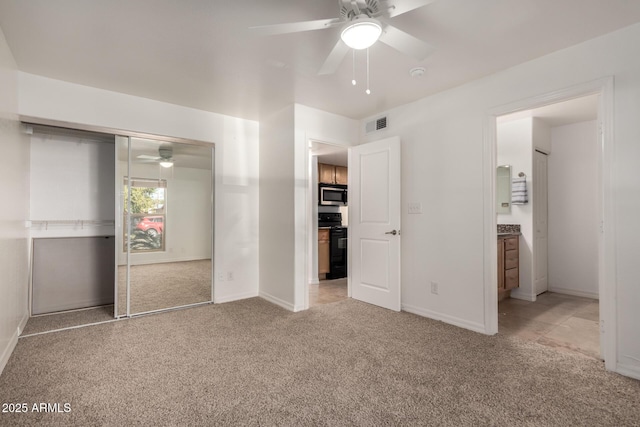 unfurnished bedroom with connected bathroom, a closet, ceiling fan, and carpet flooring