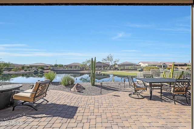 view of patio with outdoor dining space, a water view, and a residential view