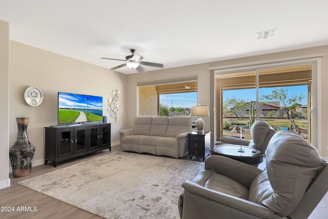 living area featuring visible vents, ceiling fan, wood finished floors, and baseboards