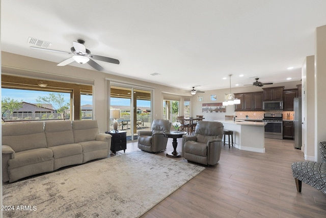 living area featuring visible vents, wood finished floors, ceiling fan, and recessed lighting