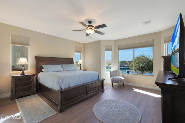 bedroom with baseboards, visible vents, wood finished floors, and ceiling fan