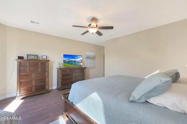 bedroom featuring wood finished floors, ceiling fan, visible vents, and baseboards