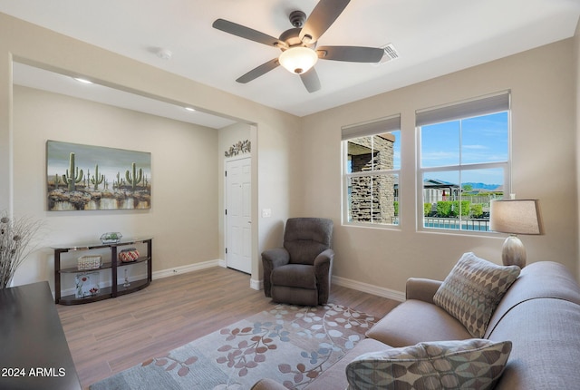 sitting room with wood finished floors, ceiling fan, visible vents, and baseboards