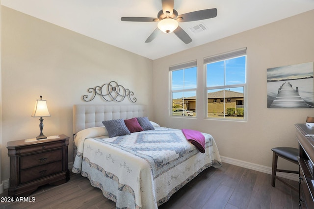 bedroom with baseboards, visible vents, ceiling fan, and dark wood finished floors