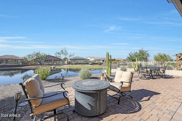 view of patio / terrace with fence, outdoor dining space, and a water view