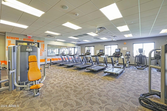 workout area with visible vents, carpet, and a paneled ceiling