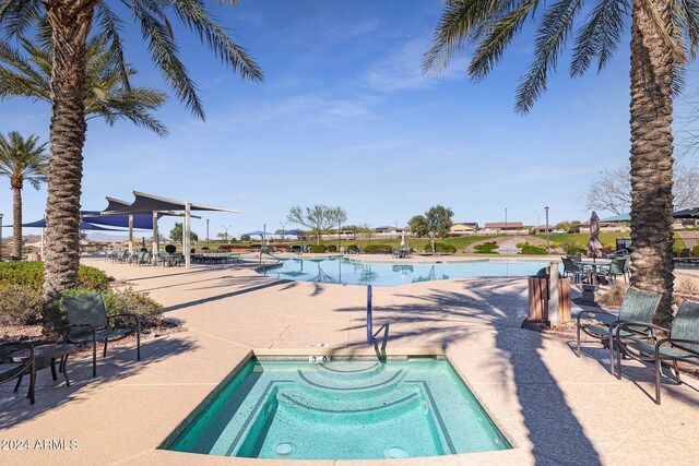 view of swimming pool featuring a patio area and a hot tub