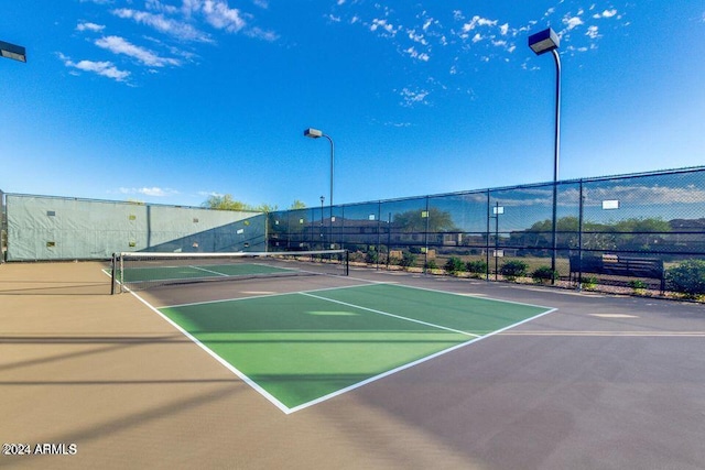 view of tennis court featuring fence and community basketball court