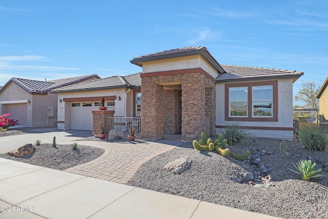 view of front of home featuring concrete driveway, an attached garage, a tiled roof, and stucco siding