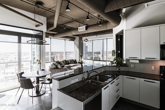 1 E Lexington Ave Unit 1209, Phoenix, AZ 85012 - kitchen with a sink, a peninsula, tasteful backsplash, open floor plan, and dark tile patterned flooring