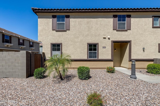 view of front of property with stucco siding and fence