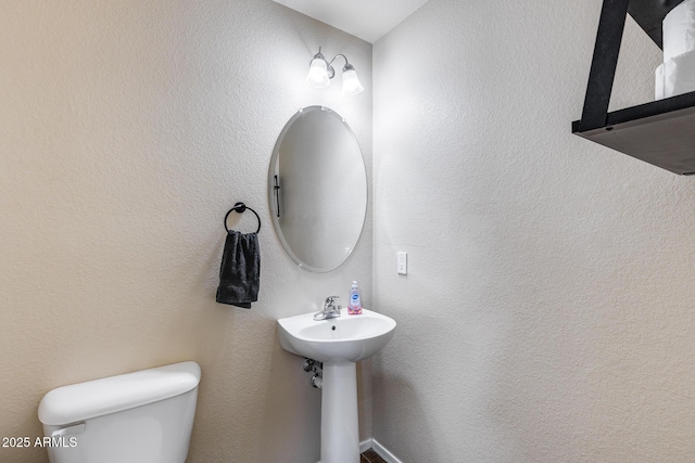 half bathroom featuring a sink and toilet