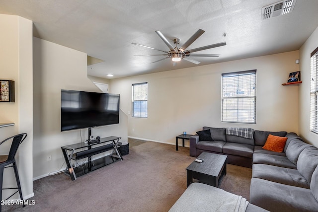 carpeted living area with baseboards, ceiling fan, and visible vents