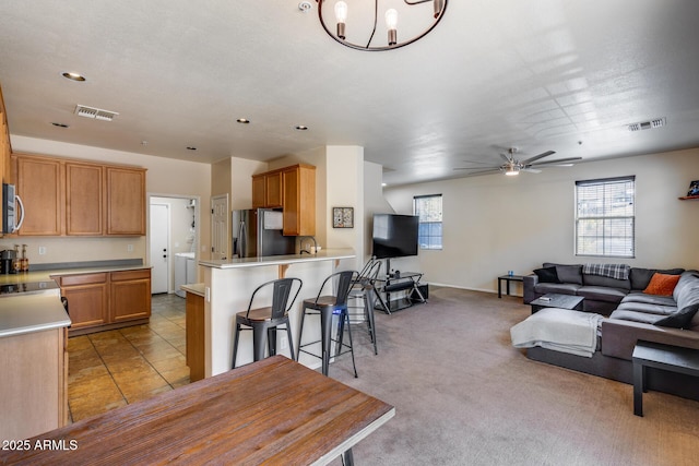 living room with visible vents, recessed lighting, ceiling fan with notable chandelier, and light carpet