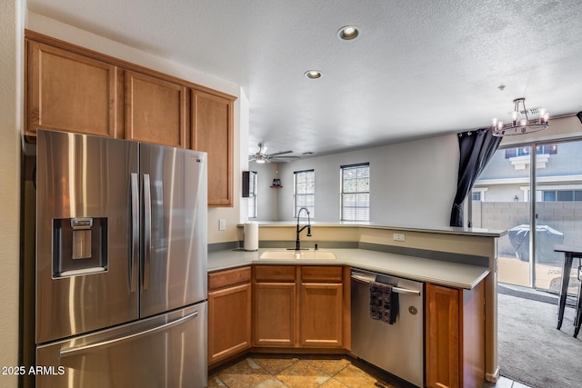 kitchen featuring a sink, a peninsula, a wealth of natural light, and stainless steel appliances