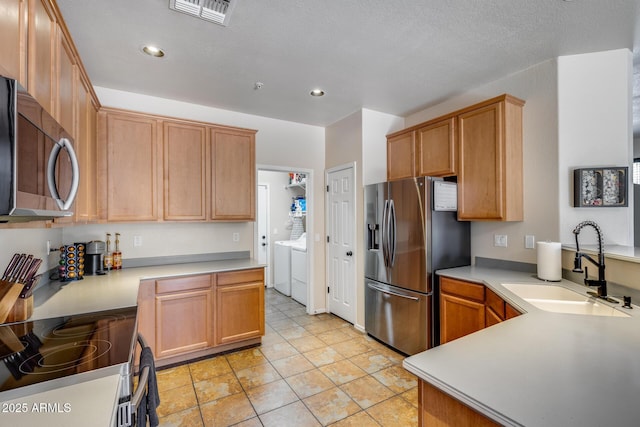 kitchen with visible vents, washing machine and dryer, a sink, stainless steel appliances, and recessed lighting