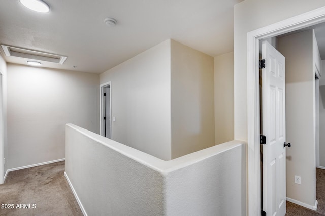 corridor with baseboards, carpet flooring, attic access, and an upstairs landing