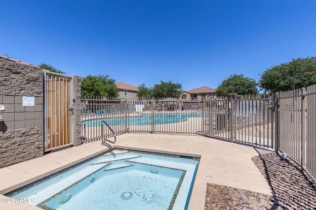 pool with fence, a patio, and a community hot tub