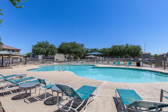 pool with a patio, fence, and a gazebo