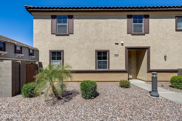 view of front of home featuring fence and stucco siding