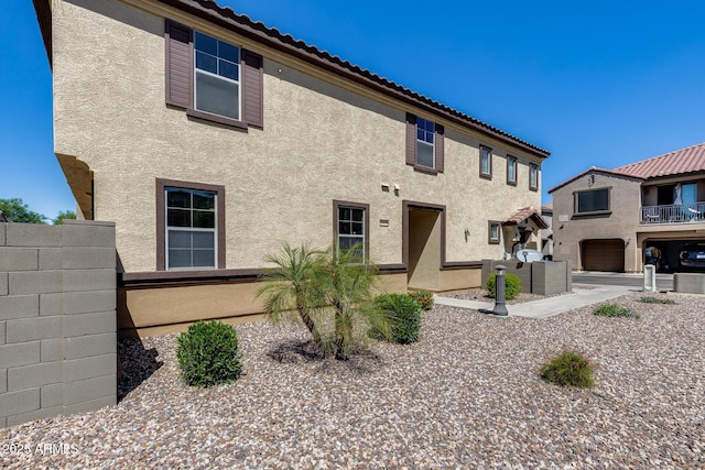 view of front facade with fence and stucco siding