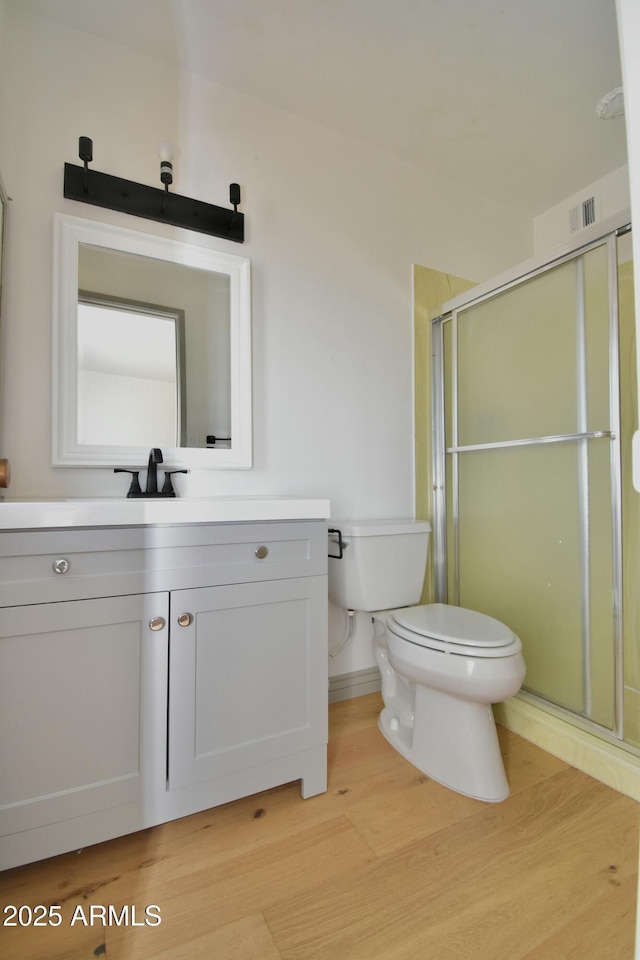 bathroom featuring vanity, wood-type flooring, and walk in shower