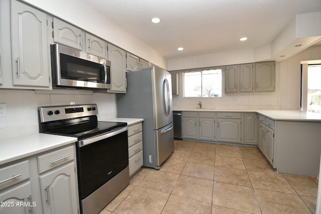 kitchen with light tile patterned flooring, sink, gray cabinetry, a textured ceiling, and stainless steel appliances