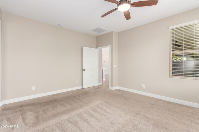 spare room featuring light carpet and ceiling fan