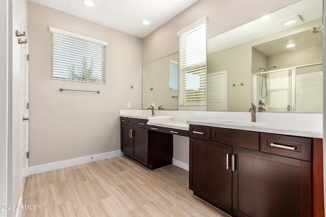 bathroom with a wealth of natural light, vanity, and an enclosed shower