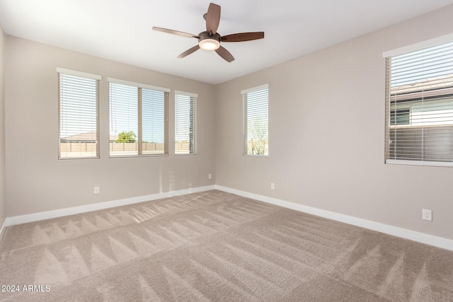 empty room featuring light carpet, plenty of natural light, and ceiling fan