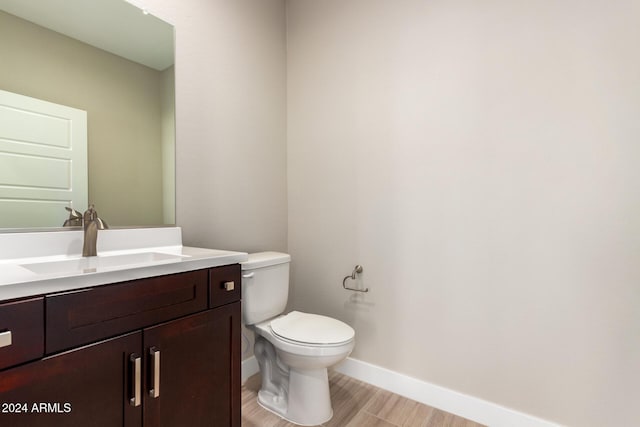 bathroom featuring hardwood / wood-style flooring, vanity, and toilet