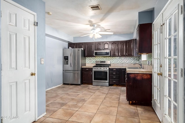 kitchen featuring tasteful backsplash, dark brown cabinets, light tile patterned floors, ceiling fan, and stainless steel appliances