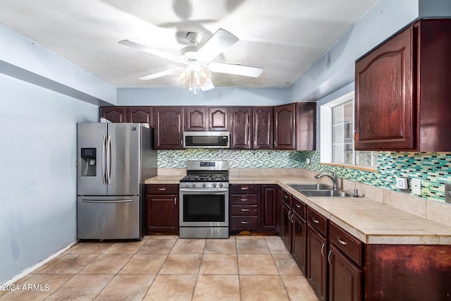 kitchen with light tile patterned flooring, sink, decorative backsplash, ceiling fan, and stainless steel appliances