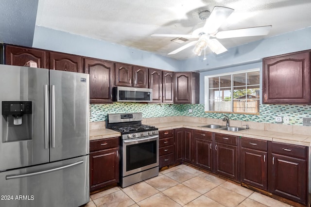 kitchen featuring light tile patterned flooring, sink, decorative backsplash, dark brown cabinetry, and stainless steel appliances