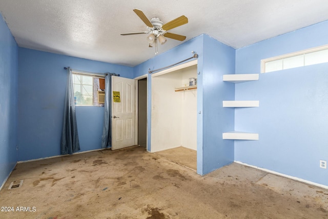 carpeted empty room featuring a textured ceiling and ceiling fan