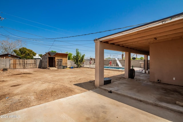 exterior space featuring an outbuilding, a pool, and a patio